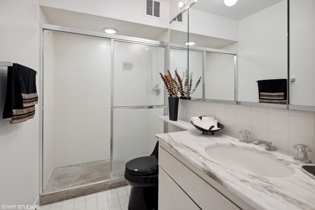 bathroom with decorative backsplash, vanity, an enclosed shower, and toilet