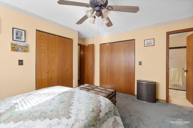 bedroom with ceiling fan, light colored carpet, crown molding, and two closets