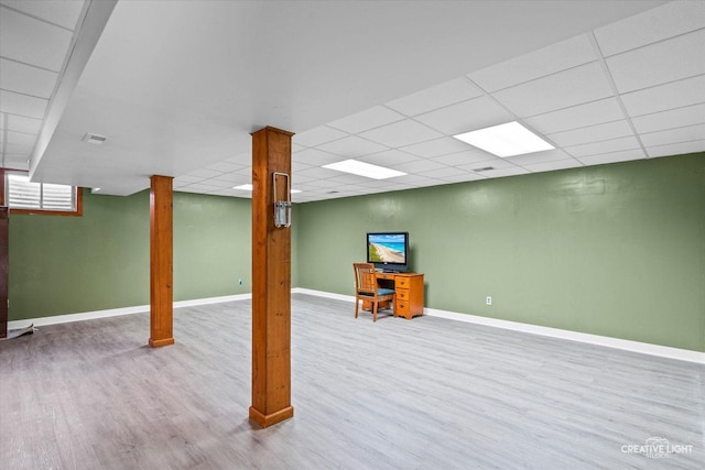 basement with a drop ceiling and light wood-type flooring