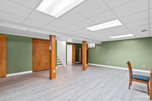 basement with a drop ceiling and light wood-type flooring