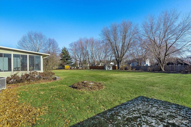 view of yard with a sunroom and a storage shed