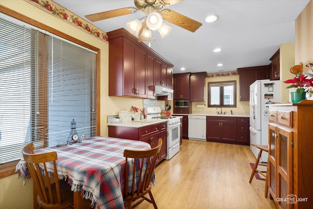 kitchen featuring ceiling fan, tasteful backsplash, white appliances, and light hardwood / wood-style flooring