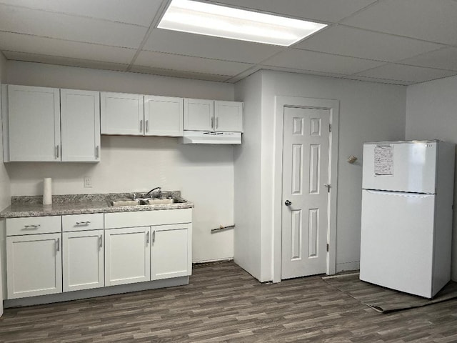 kitchen with a paneled ceiling, sink, white refrigerator, white cabinets, and dark hardwood / wood-style floors