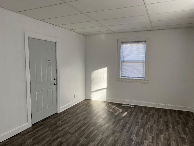 341 S Harrison Ave, Kankakee, IL 60901 - spare room featuring a paneled ceiling, baseboards, and dark wood-style flooring