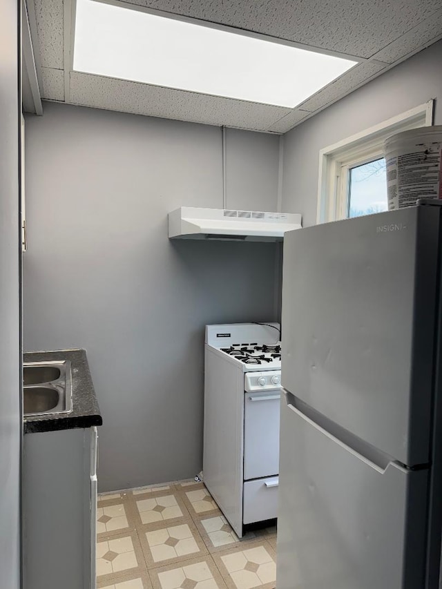 341 S Harrison Ave, Kankakee, IL 60901 - kitchen featuring light floors, under cabinet range hood, freestanding refrigerator, and white gas range