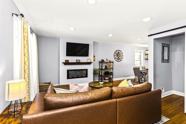 living room with a wealth of natural light and dark wood-type flooring