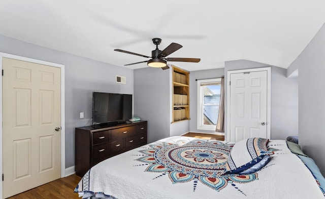 bedroom with dark hardwood / wood-style flooring, lofted ceiling, and ceiling fan