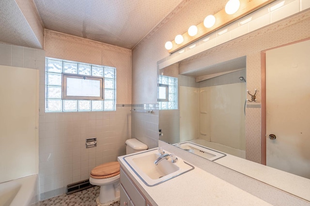 bathroom with vanity, toilet, and tile walls