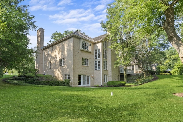 view of home's exterior with a yard and french doors