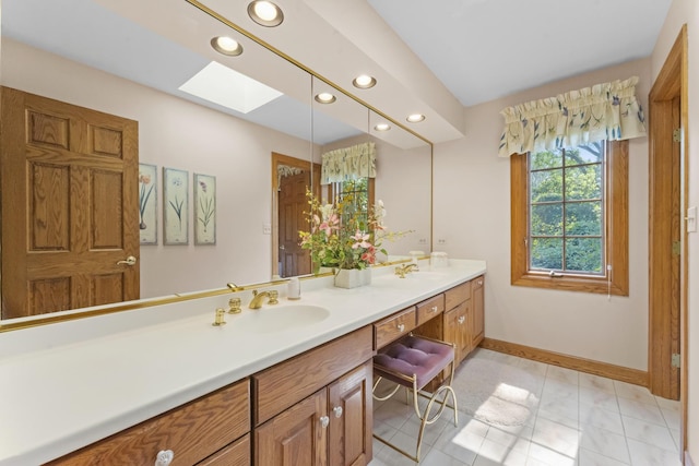 bathroom with tile patterned floors, vanity, and a skylight