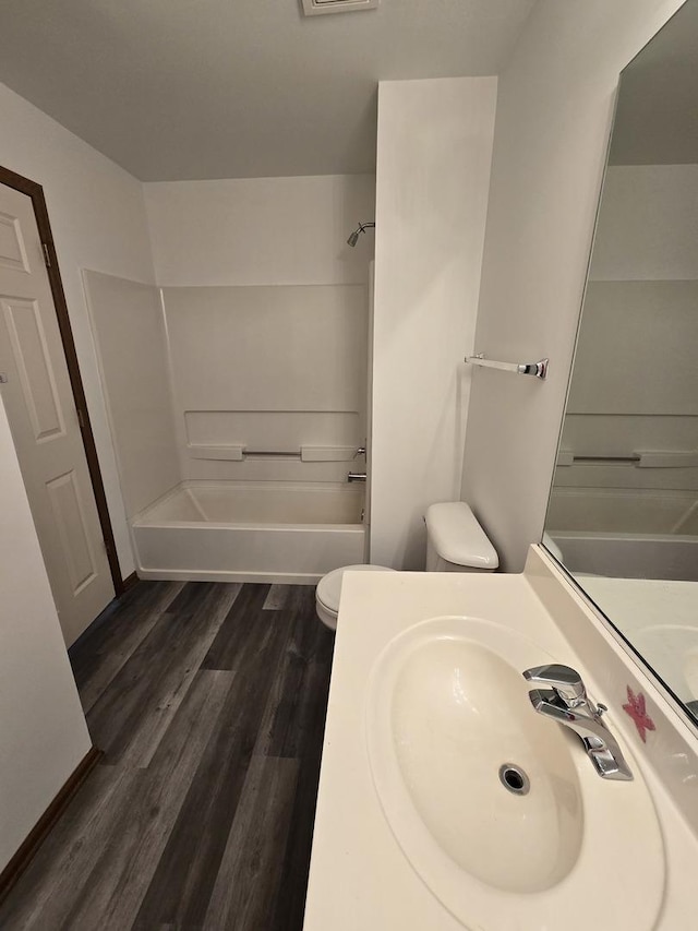 full bathroom featuring hardwood / wood-style floors, toilet, shower / tub combination, and sink