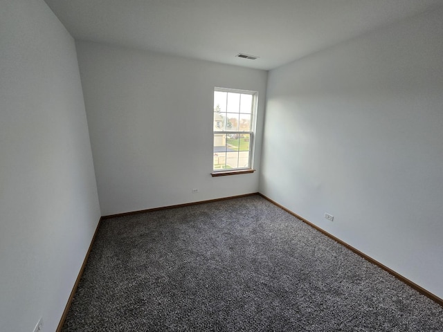 unfurnished room with dark colored carpet