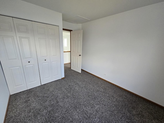 unfurnished bedroom featuring a closet and dark colored carpet