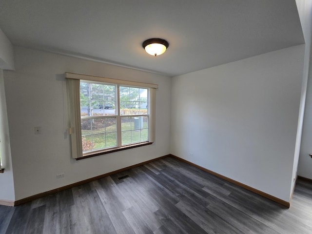 unfurnished room with dark wood-type flooring