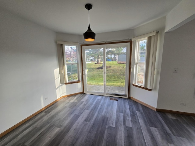 unfurnished dining area featuring dark wood-type flooring