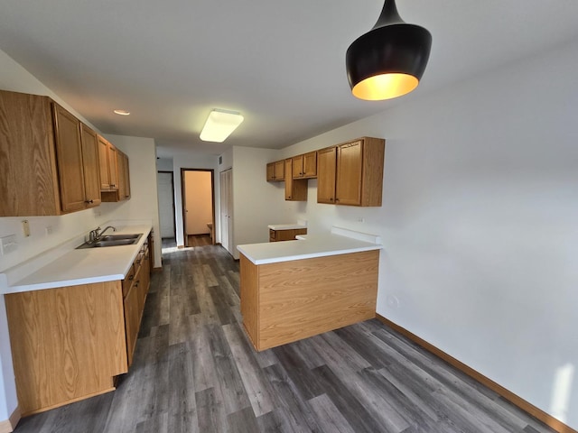 kitchen featuring pendant lighting, dark hardwood / wood-style floors, and sink