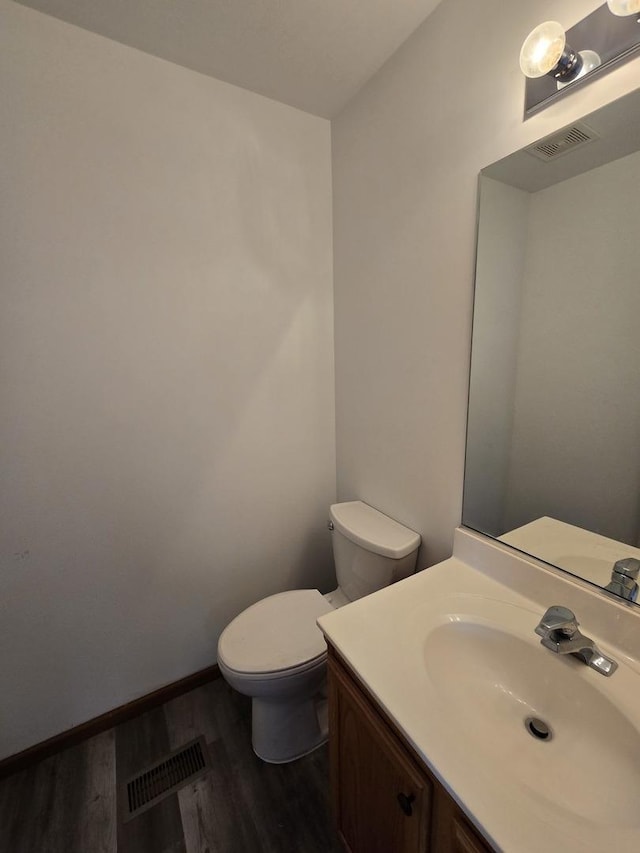 bathroom featuring toilet, vanity, and hardwood / wood-style flooring