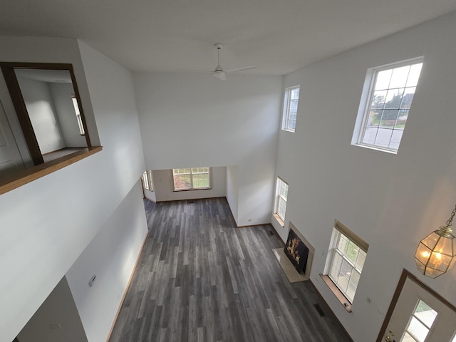 hallway with dark hardwood / wood-style flooring and a towering ceiling