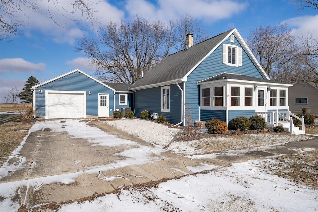 505 W N St, Stanford, IL 61774 - view of front of home with a chimney, driveway, a garage, a shingled roof, and a sunroom