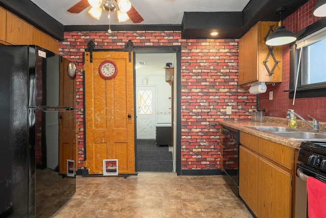 kitchen with brick wall, sink, pendant lighting, and black appliances