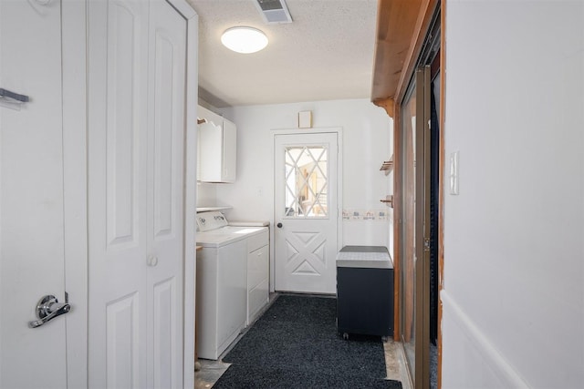 laundry room with cabinets, washing machine and clothes dryer, and a textured ceiling