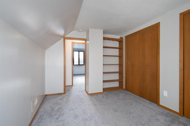 bonus room featuring light colored carpet and vaulted ceiling