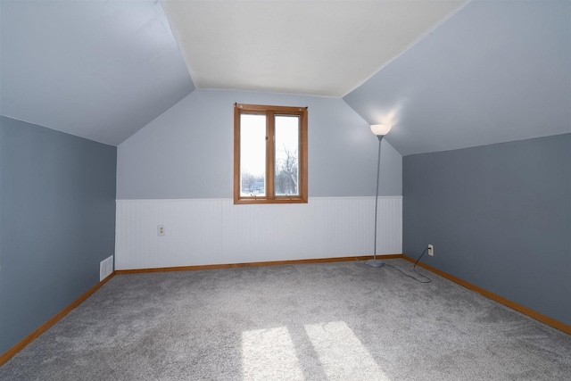 bonus room with vaulted ceiling and carpet floors