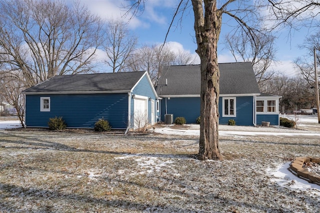 view of front of property with a garage, central AC unit, and a sunroom