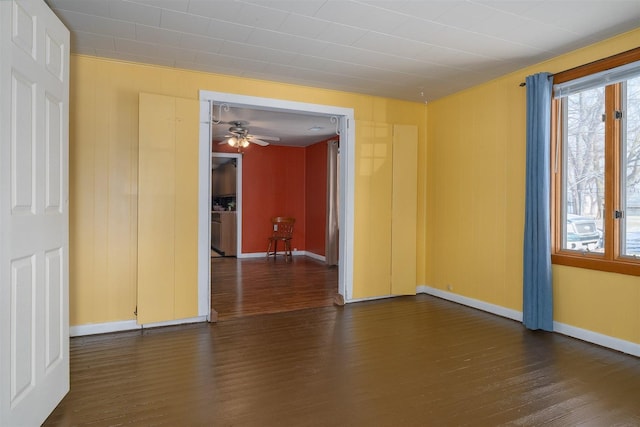 spare room featuring dark wood-type flooring and ceiling fan