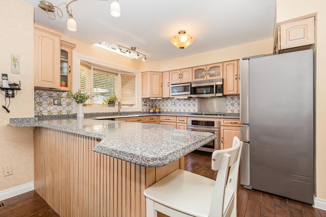 2921 Autumn Dr, Woodridge, IL 60517 - kitchen featuring appliances with stainless steel finishes, a peninsula, light brown cabinetry, a kitchen bar, and glass insert cabinets