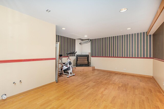 2921 Autumn Dr, Woodridge, IL 60517 - empty room with wood finished floors, recessed lighting, wallpapered walls, and a wood stove