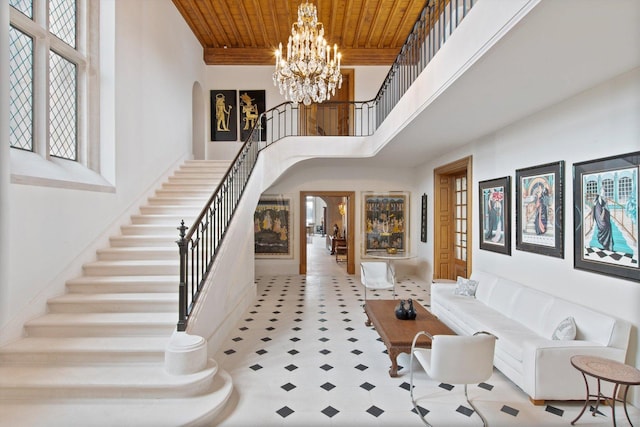 foyer with a chandelier, a towering ceiling, and wood ceiling