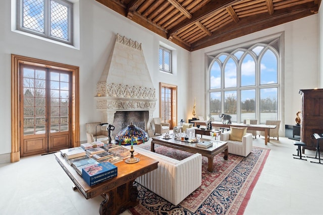 living room with wooden ceiling, french doors, a premium fireplace, a towering ceiling, and beam ceiling