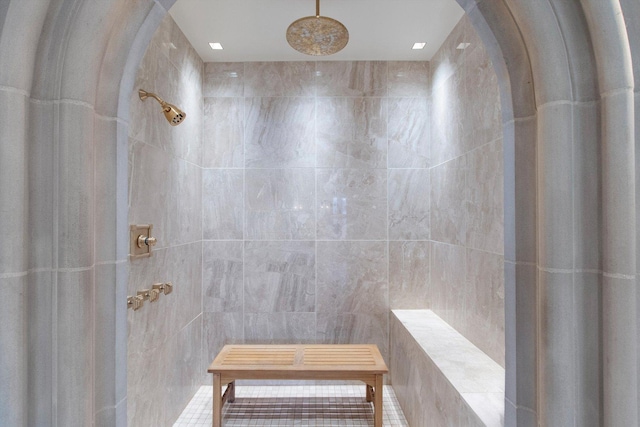 bathroom featuring walk in shower and tile walls