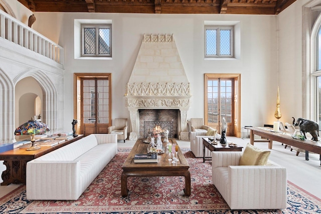 living room featuring a fireplace, french doors, and a towering ceiling