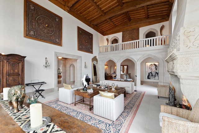 living room featuring beam ceiling, a towering ceiling, wooden ceiling, and coffered ceiling