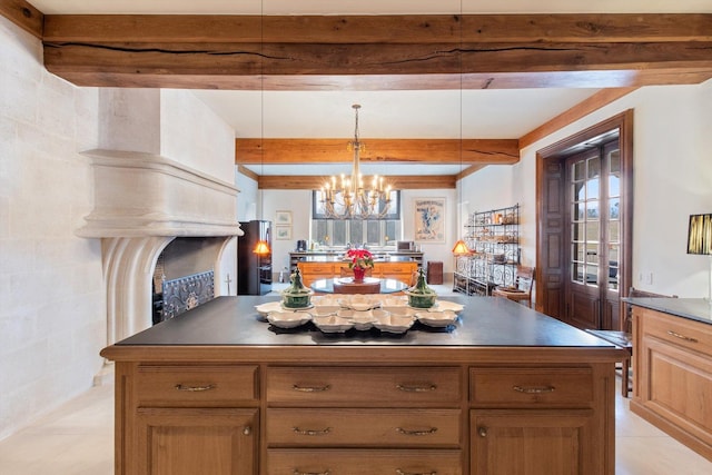 kitchen featuring beam ceiling, a center island, hanging light fixtures, and an inviting chandelier