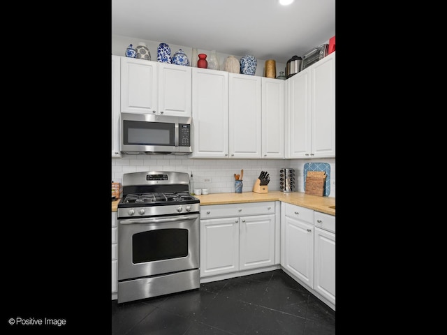 kitchen featuring tasteful backsplash, appliances with stainless steel finishes, white cabinets, and wood counters