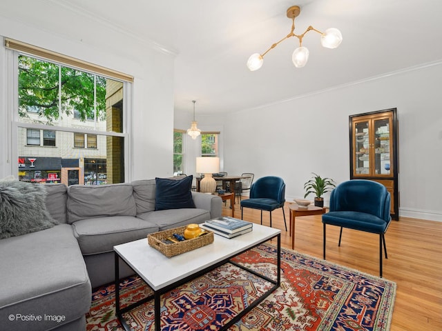 living room with ornamental molding, a chandelier, hardwood / wood-style floors, and a wealth of natural light