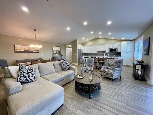 living room with light hardwood / wood-style flooring, vaulted ceiling, and a chandelier