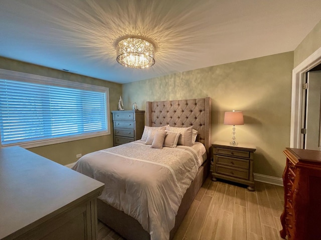 bedroom featuring a notable chandelier and light hardwood / wood-style floors