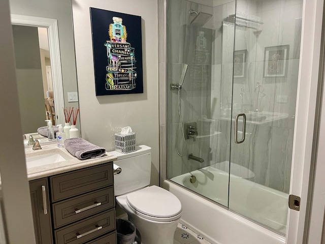 full bathroom featuring vanity, combined bath / shower with glass door, and toilet