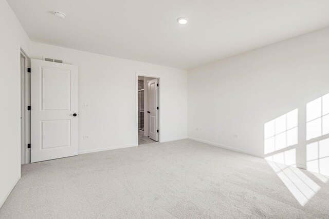 unfurnished room featuring light colored carpet