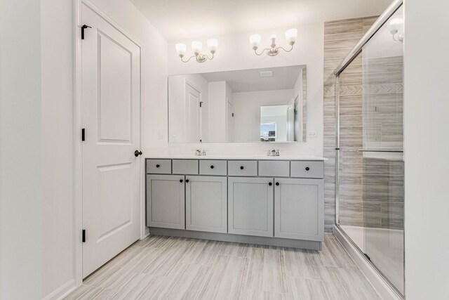 bathroom featuring vanity, a shower with door, and an inviting chandelier