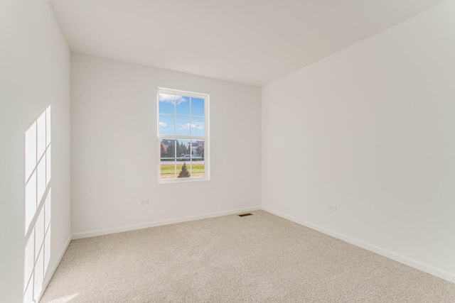 spare room featuring light colored carpet