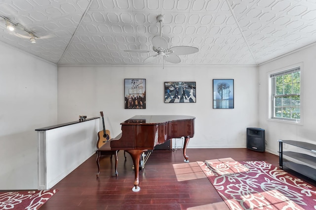 misc room with rail lighting, dark hardwood / wood-style floors, ceiling fan, and crown molding