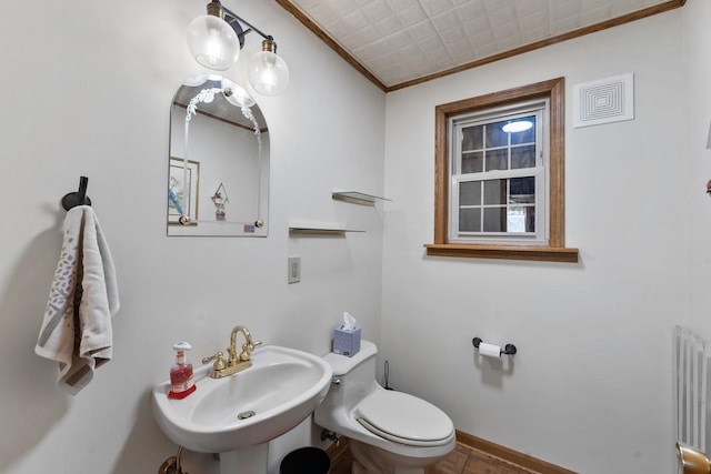 bathroom with radiator, toilet, sink, and ornamental molding