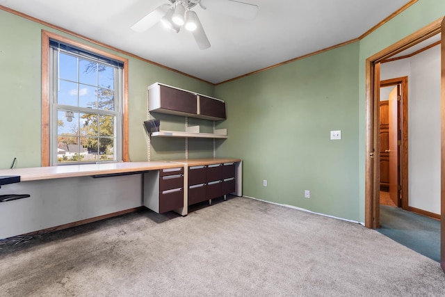 unfurnished office featuring ceiling fan, ornamental molding, and light carpet