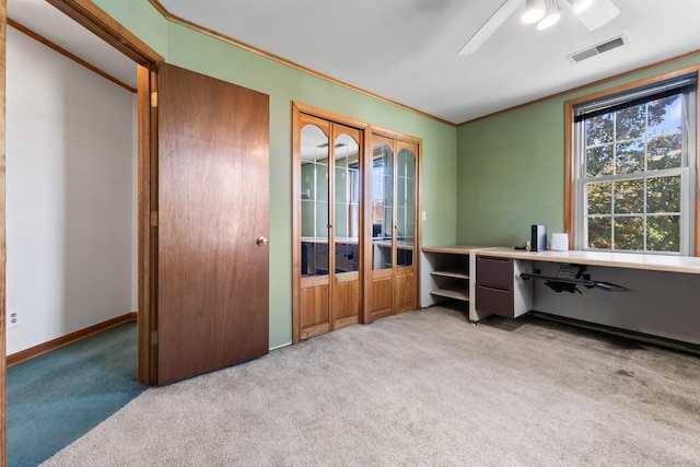 carpeted office space featuring ceiling fan and ornamental molding