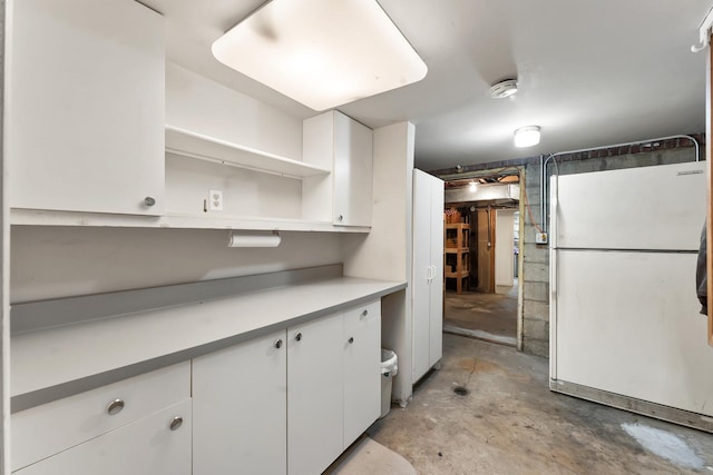 kitchen featuring white fridge and white cabinetry